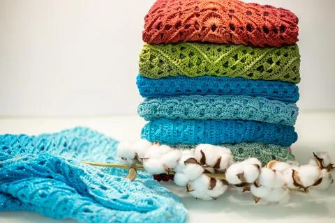 A stack of multi-colored knitted things on a white background Stock Photos