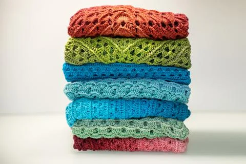A stack of multi-colored knitted things on a white background Stock Photos