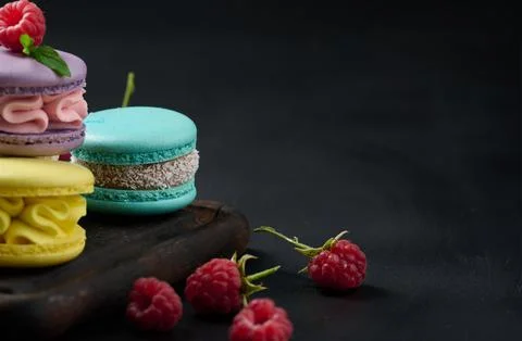 A stack of multi-colored macaroons on a wooden board. Delicious dessert 스톡 사진