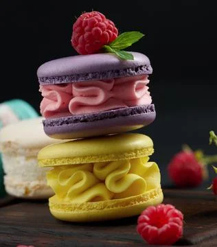 A stack of multi-colored macaroons on a wooden board. Delicious dessert Stock Photos