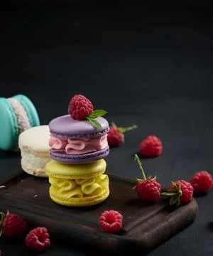 A stack of multi-colored macaroons on a wooden board. Delicious dessert Stock Photos