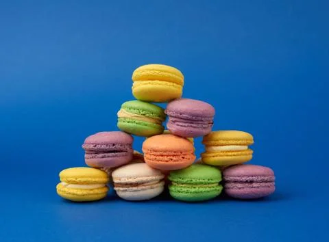 Stack of multi-colored round baked macarons cakes on a dark blue background Stockfoto's