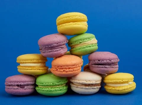 Stack of multi-colored round baked macarons cakes on a dark blue background Stockfoto's
