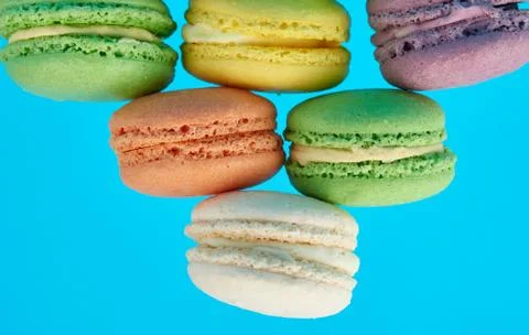 Stack of multi-colored round baked macarons cakes on a blue background Stock-Fotos