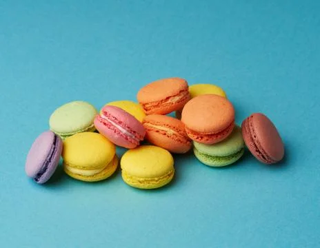 Stack of multi-colored round baked macarons cakes on a blue background Stock-Fotos