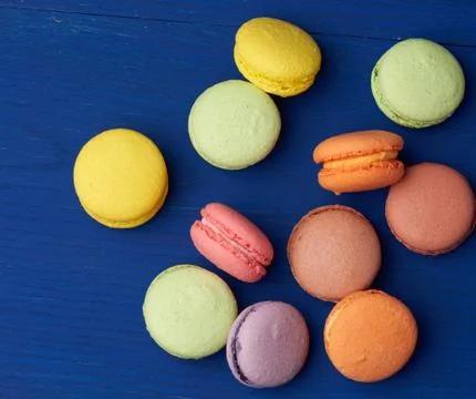 Stack of multi-colored round baked macarons cakes on a blue wooden background Stock Photos