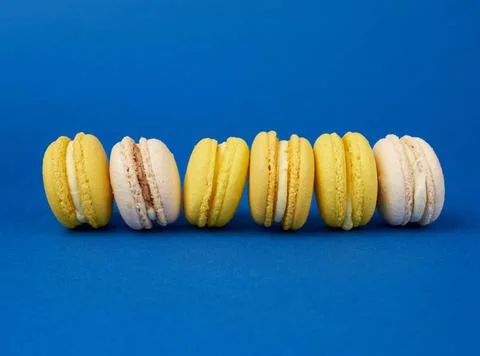 Stack of multi-colored round baked macarons cakes on a dark blue backgroun... Stock-Fotos