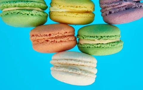 Stack of multi-colored round baked macarons cakes on a blue background sta... Stockfoto's