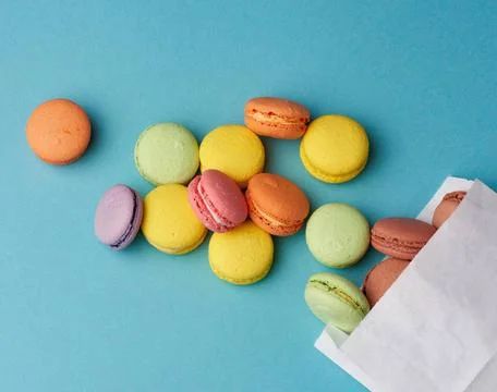 Stack of multi-colored round baked macarons cakes on a blue background sta... Stock-Fotos