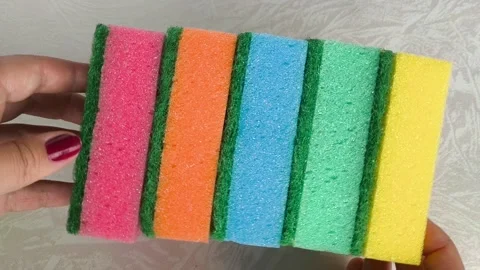 A stack of multi-colored sponges in a womans hands close-up. Sponges for washing Stock Footage 318206546