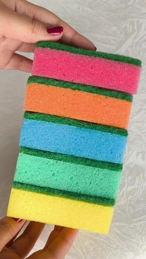 A stack of multi-colored sponges in a womans hands close-up. Sponges for washing Stock Footage 318206623