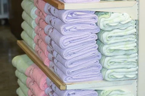 Stack of the multicolored towels on shelf Stock Photos
