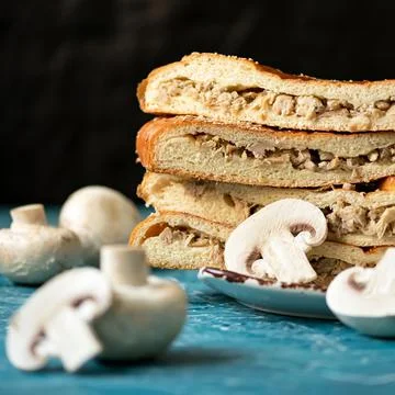 Stack of mushroom pie on black background. Pie with champignon. Fresh baking Stock Photos
