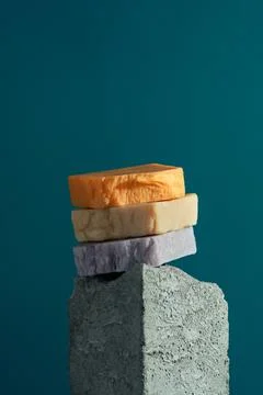Stack of natural homemade soap bars on a granite cube, blue background, Stock Photos
