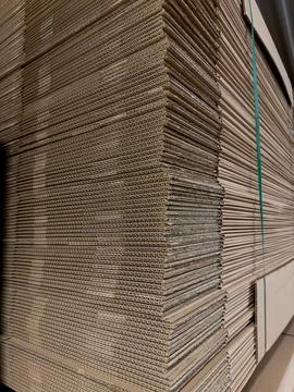 Stack of neatly arranged cardboard sheets in a warehouse, showcasing the co.. Foto stock