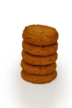 Stack of neatly arranged cookies on plain white background with warm brown .. 스톡 사진