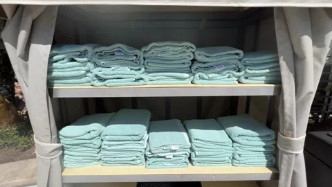 Stack of Neatly Folded Aqua Pool Towels on Outdoor Resort Shelving Stock Footage 345369808