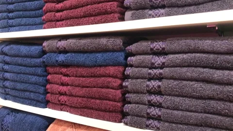 Stack of neatly folded colorful towels on retail store shelves in a home go.. Stock Footage 337806314