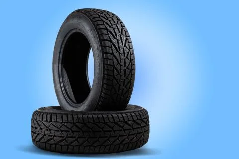 Stack of new black tyres for winter car on blue background Stock Photos