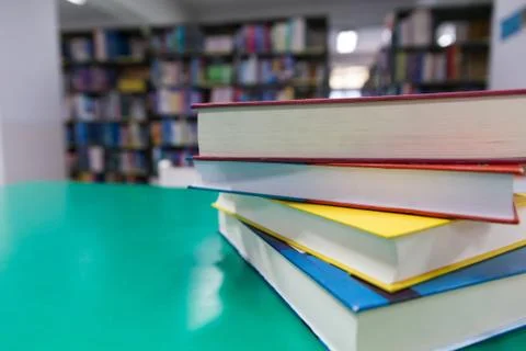 A stack of new books on table with blur book in library, education background Stock Photos