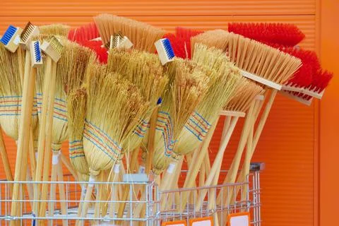 Stack of new diferent brooms, brushes and besoms in front of store Фото