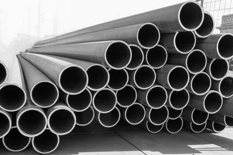 Stack of new, even, long pipelines. Monochrome photo. Stock Photos