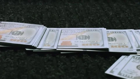 Stack of new one hundred dollar bills fanned out on dark textured surface. Stock Footage 337599141