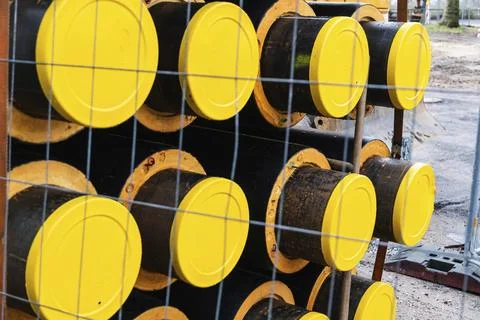 A stack of new pipes for a district heating pipeline on a construction site in Stock Photos