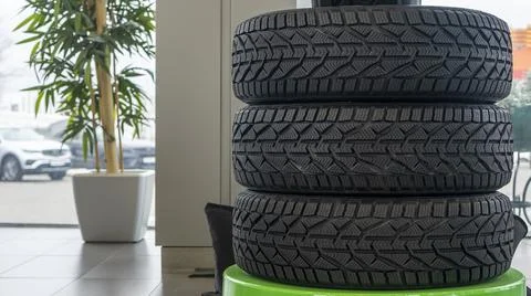 Stack of new winter tires. Group of automotive tires for snow road. Selective Stock Photos