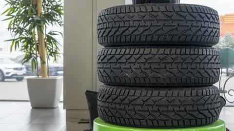 Stack of new winter tires. Group of automotive tires for snow road. Selective Stock Photos