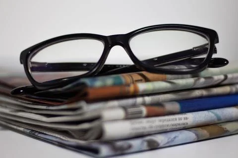 Stack of newspapers and glasses in black and white Stock Photos