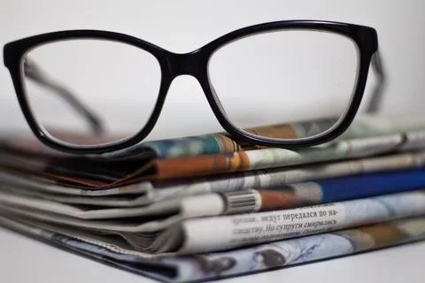 Stack of newspapers and glasses in black and white Stock Photos