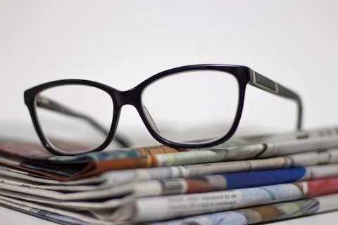 Stack of newspapers and glasses in black and white 写真素材