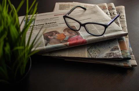 Stack of newspapers and glasses in black and white Stock Photos