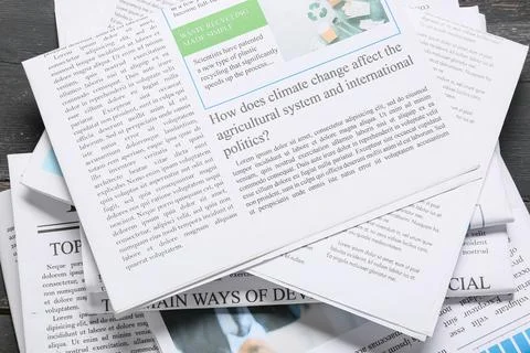 Stack of newspapers with climate change and recycling headlines, global polit Stock Photos
