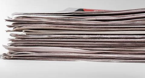 Stack of newspapers isolated on gray. Stock Photos