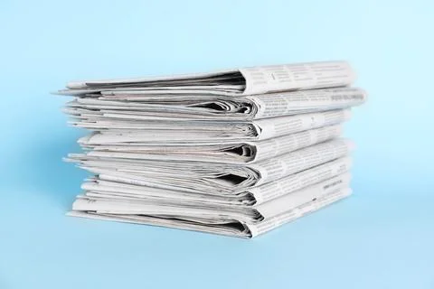 Stack of newspapers on light blue background 스톡 사진
