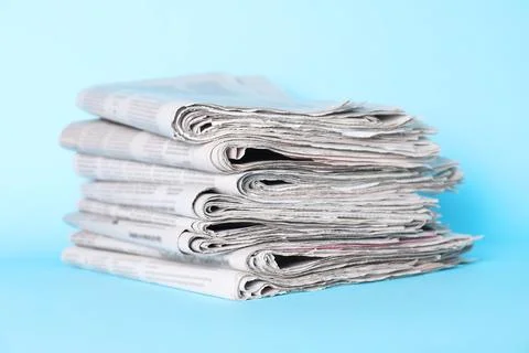 Stack of newspapers on light blue background 스톡 사진