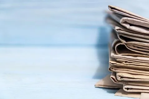 Stack of newspapers to read on blue background with advertising space Stock Photos