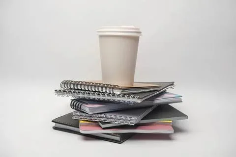 Stack of notebooks and coffee cup on white background Stock Photos