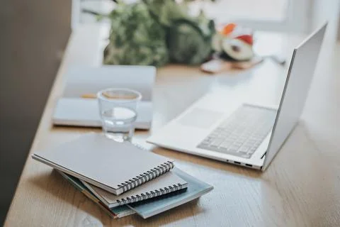 A stack of notebooks and notepads in the foreground. In the background is a Stock Photos
