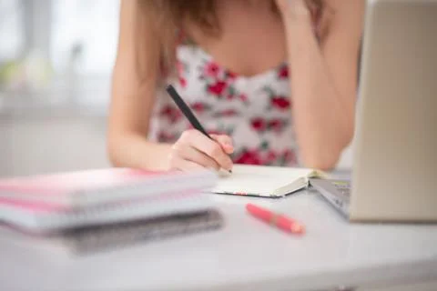 A stack of notebooks on the spiral girl student at the laptop Stock Photos
