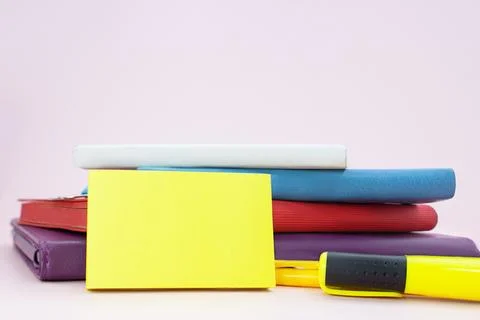 Stack of notepads with marker on pink table with sticky sticker Foto stock