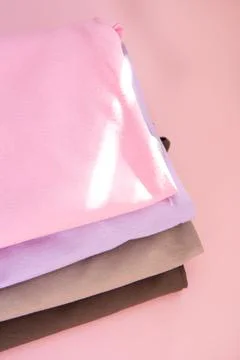 Stack of nude pink clothes on pink background and the rays of the sun Foto stock