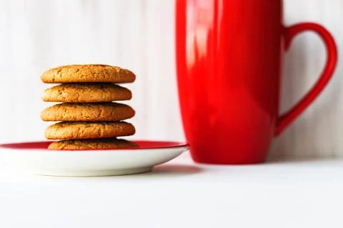 Stack of oatmeal cookie on red plate with coffee cup on white wooden table Stock Photos