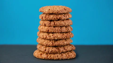 Stack of oatmeal cookies appearing on blue background. Tasty bakery dessert. Stock Footage 223730027