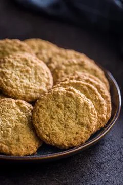 Stack of oatmeal cookies on plate with some placed beside it in a kitchen s.. Stock Photos