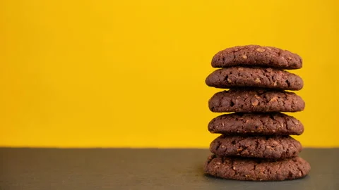 Stack oatmeal cookies rotating on yellow background. Food concept with copyspace Stock Footage 219312449