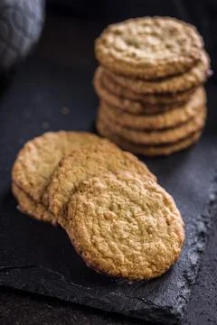 Stack of oatmeal cookies on slate with some placed beside it in a kitchen s.. 스톡 사진
