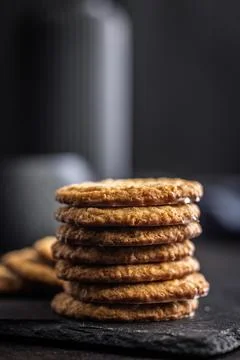 Stack of oatmeal cookies on slate with some placed beside it in a kitchen s.. 스톡 사진